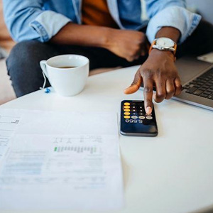 A man calculating wage & expenses with a calculator- Moss Bollinger LLP