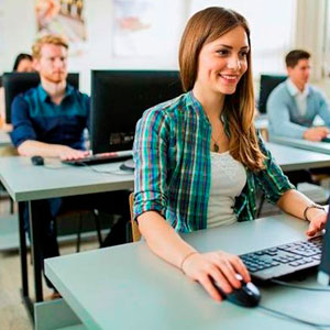 A Student smiling while using a computer to work on a project- Moss Bollinger LLP