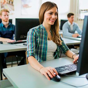 A woman smiling while using a computer to work on a project- Moss Bollinger LLP