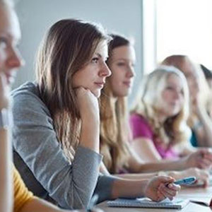 A diverse group of students engaged in a classroom discussion while sitting around a table- Moss Bollinger LLP