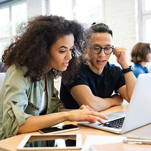 Two individuals focused on a laptop screen in a professional setting- Moss Bollinger LLP