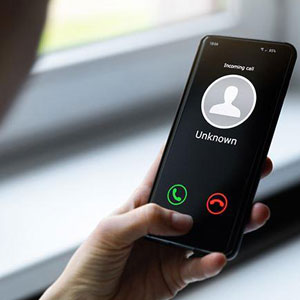 A woman on her smartphone, wary of IRS phone scams- Moss Bollinger LLP