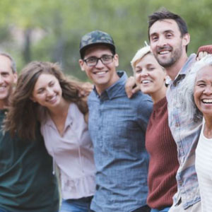 A joyful gathering of individuals sharing laughter and smiles, radiating happiness and camaraderie- Moss Bollinger LLP