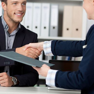 A man in a suit shaking hands with another man- Moss Bollinger LLP