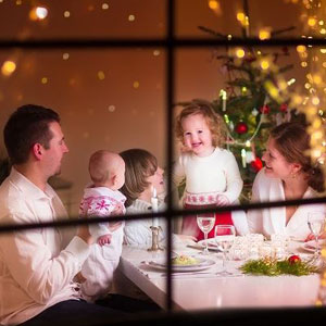 Family celebrating holiday meal with Christmas tree in background- Moss Bollinger LLP