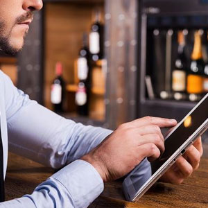 A professional man in a suit using a tablet computer for work purposes- Moss Bollinger LLP