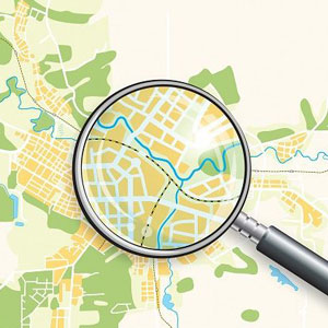 Colorful map with roads, water bodies; magnifying glass zooms in on intersection- Moss Bollinger LLP
