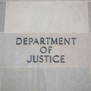 Gray stone wall with expertly engraved 'DEPARTMENT OF JUSTICE' in bold capitals, forming a striking contrast- Moss Bollinger LLP