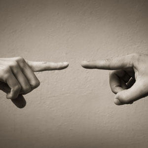 Two hands, reaching towards each other but not quite touching. A silent dance of connection and longing- Moss Bollinger LLP