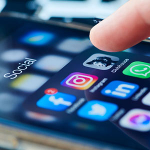 hand touching smartphone screen displaying social media icons - Moss Bollinger LLP