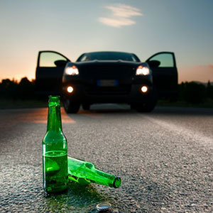 A damaged car on the side of the road, surrounded by broken glass and debris - Moss Bollinger LLP