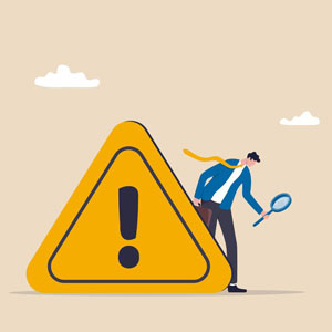 Businessman holding a tennis racket while standing next to a yellow caution sign - Moss Bollinger LLP
