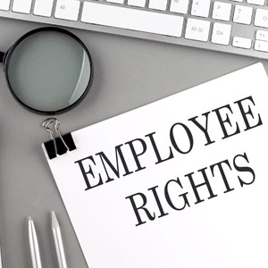 Employee rights on paper with pen and glasses: being signed with a pen, next to a pair of glasses. - Moss Bollinger LLP