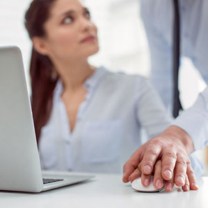 A couple holding hands and looking at a laptop, involved in sexual harassment behavior - Moss Bollinger LLP